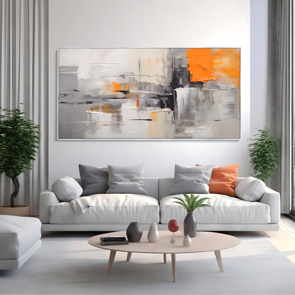 Tablou canvas cu pictura abstracta gri cu pata portocalie, in rama de aluminiu argintiu, pe perete intr-un living
